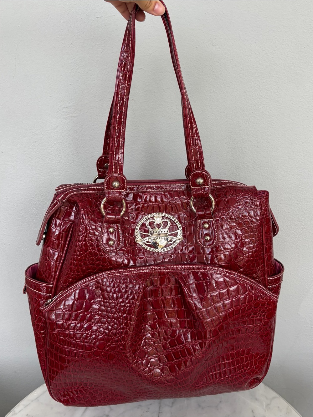 Kathy Van Zeeland - a deep red croc-embossed PVC finish and silver hardware